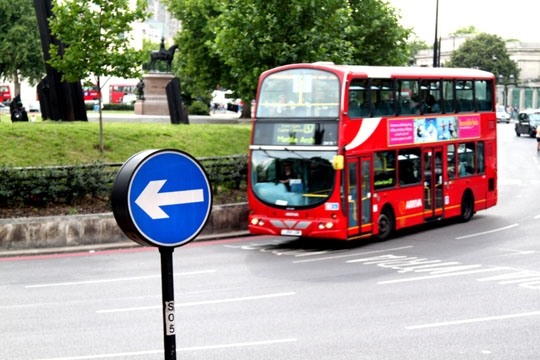 London Left Arrow Sign And Double Decker Bus